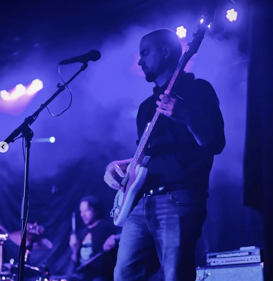 Earl Watts playing bass in atmospheric blue lighting