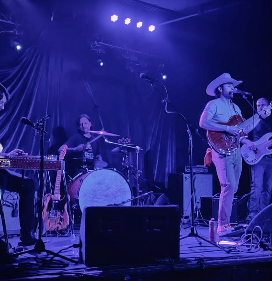 Jack Gray playing guitar under red stage lighting